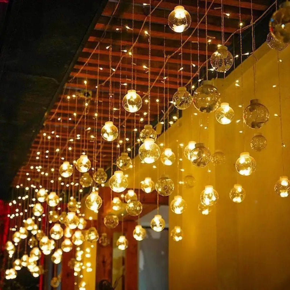Cortină luminoasă cu bile suspendate — atmosferă caldă și feerică 